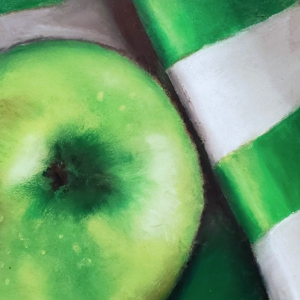 a green apple on green striped cloth